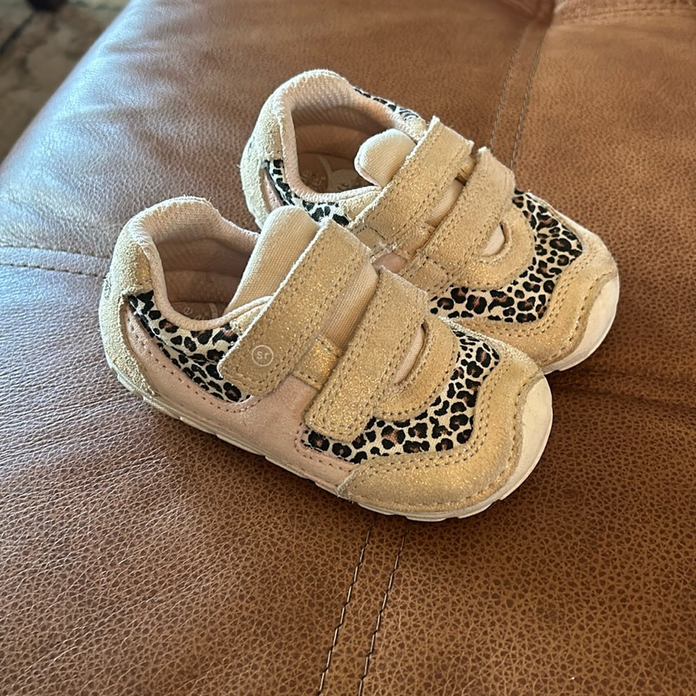 Stride right gym shoe, light pink with gold and leopard accents.